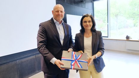 Brian Heath presents President Achtziger with a gift from the US Consulate