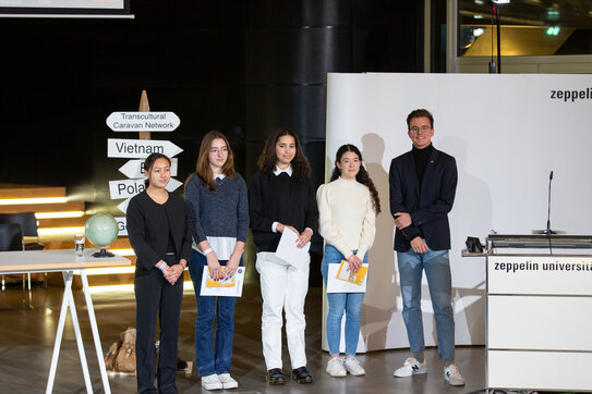 Picture ZU I Nicolas Bühringer: Winners of the TLS Essay-Competition 2022 (from left to right) Vivien Dinh (TLS Team), Noa Seeman (Montfort-Gymnasium Tettnang), Amaia Hernandez Rodriguez (Montfort-Gymnasium Tettnang), Sophia Getachew (Karl-Maybach-Gymnasium, Friedrichshafen) and Moritz Schön (Zeppelin University student vice-president)